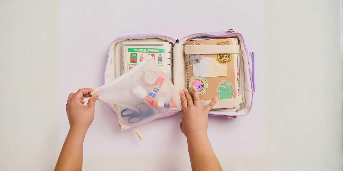 Menmin Multi Bag open on a table showing the mesh pouch, sticker sleeves and junk journal