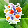 A white sticker of California poppies, California buttercups, and silver lupine.