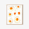 Watercolor fried egg art print in light wood frame, whimsical kitchen wall decor