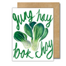 A white greeting card with a green bok choy and the words "gung hay bok choy" written in green cursive letters.