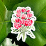 A sticker depicting a watercolor bouquet of red roses and small green bunches of leaves.