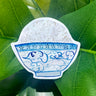 A white sticker of a blue and white watercolor bowl of rice. The bowl looks like porcelain and is decorated with blue line art clouds.