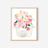 A pink, blue, and white print of a bouquet of tulips, roses, and other flowers sprouting out of a rice cooker.