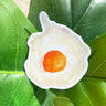 A sticker of a round, sunny side up fried egg with a cheery orange yolk.