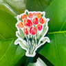 A sticker of orange and red watercolor tulips, standing on dark green stems.