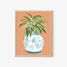 Framed art print of a spider plant in a blue and white horse-patterned vase, AAPI-inspired home decor