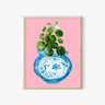 Framed art print with blue vase, green plant, and cat design on pink background, AAPI-inspired home decor