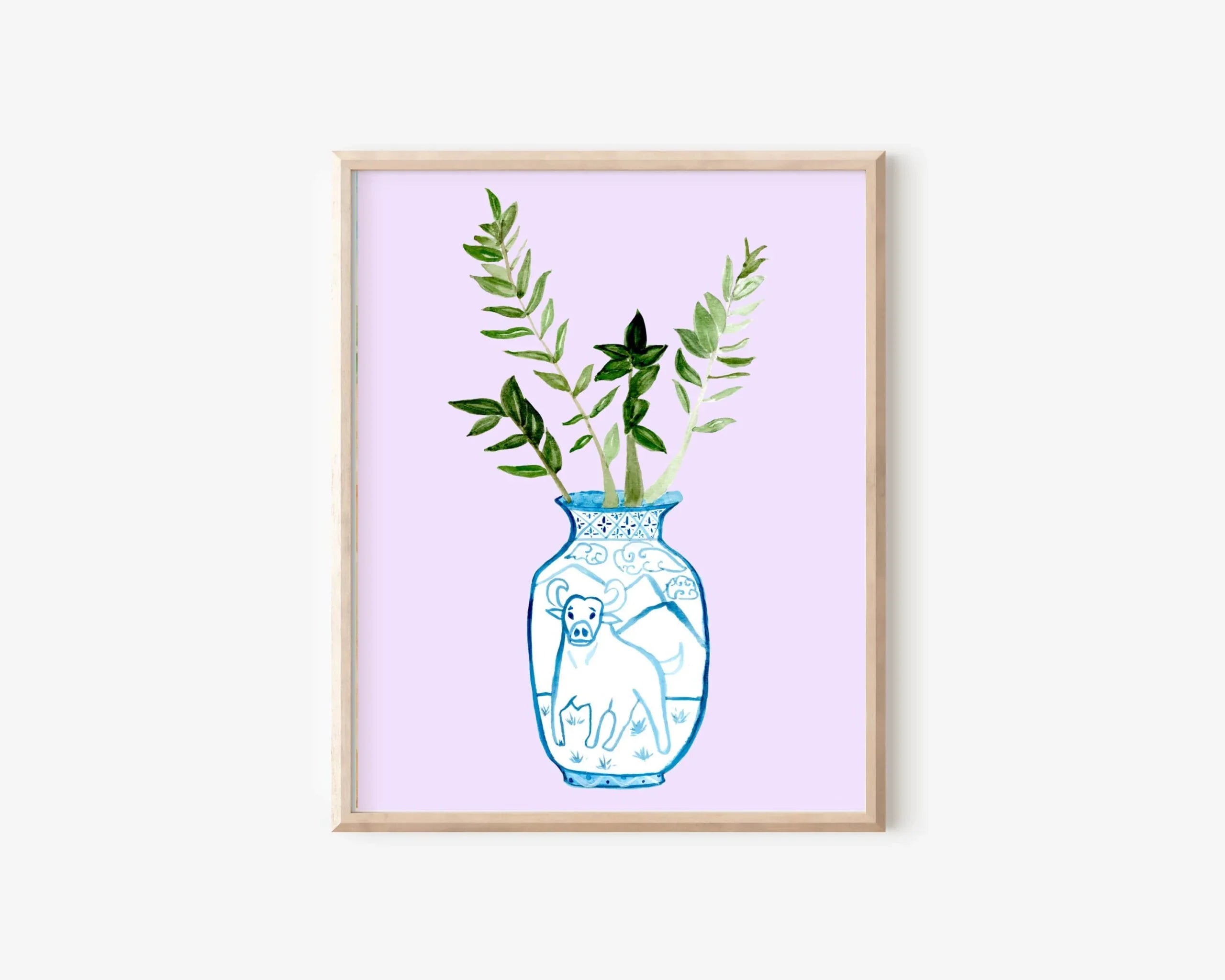 Blue and white vase with ox design, holding greenery, on lavender background