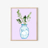 Blue and white vase with ox design, holding greenery, on lavender background