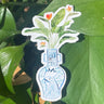 A sticker of a bird of paradise plant in a blue and white porcelain vase, decorated with a rooster.