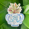 A sticker of a rattlesnake plant in a blue and white porcelain vase, decorated with a snake.